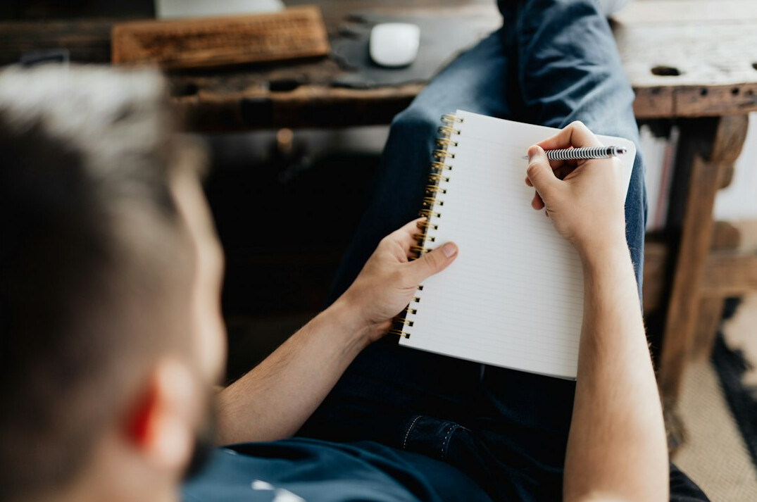 man writing notes