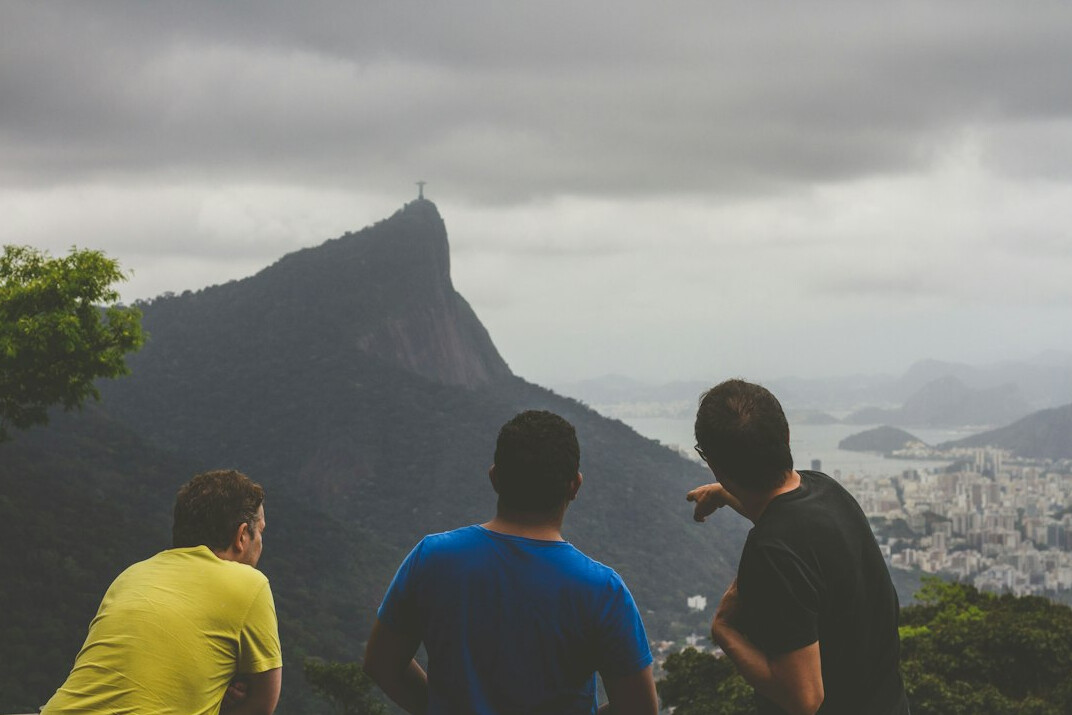 Homem brasileiro falando com confiança para um pequeno grupo